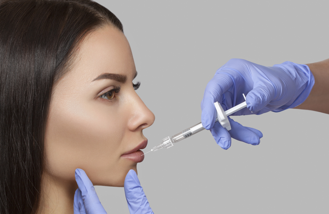 The doctor cosmetologist makes Lip augmentation procedure of a beautiful woman in a beauty salon. Prp therapy, anti wrinkle and aging skin. Cosmetology skin care.